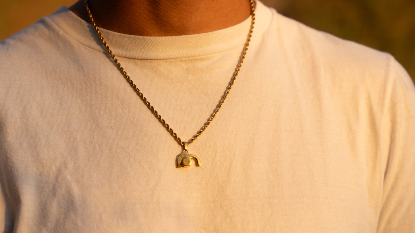 empty tomb necklace with a pendant on a person wearing a light-colored shirt.