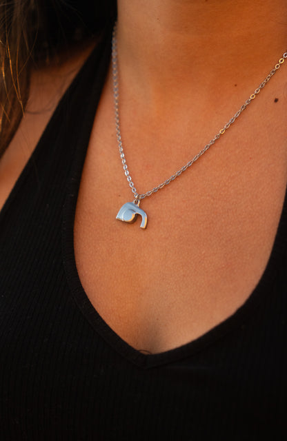 Necklace with a unique empty tomb pendant worn by a woman against a black background